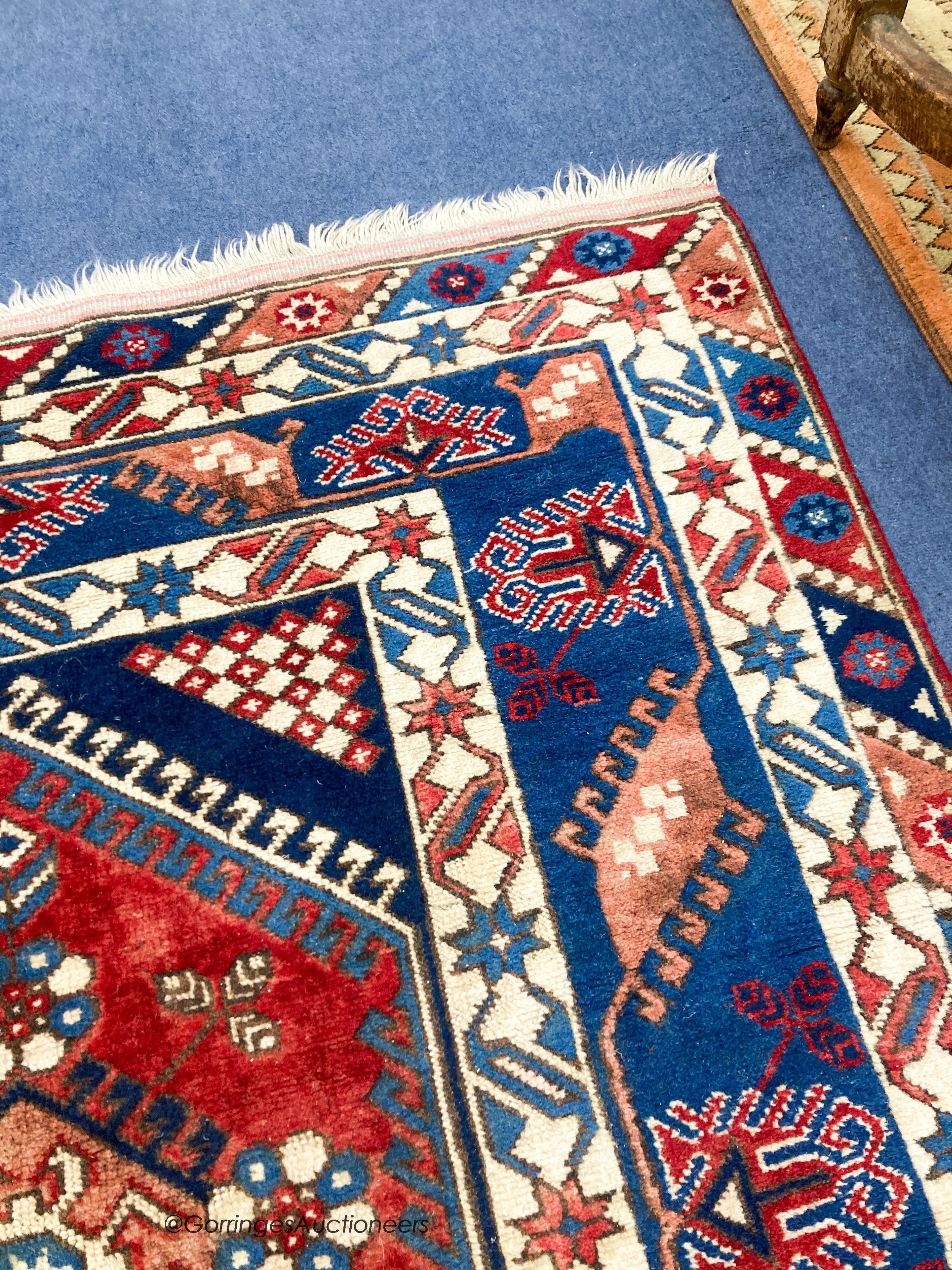 A Caucasian design blue ground rug, 240 x 152cm